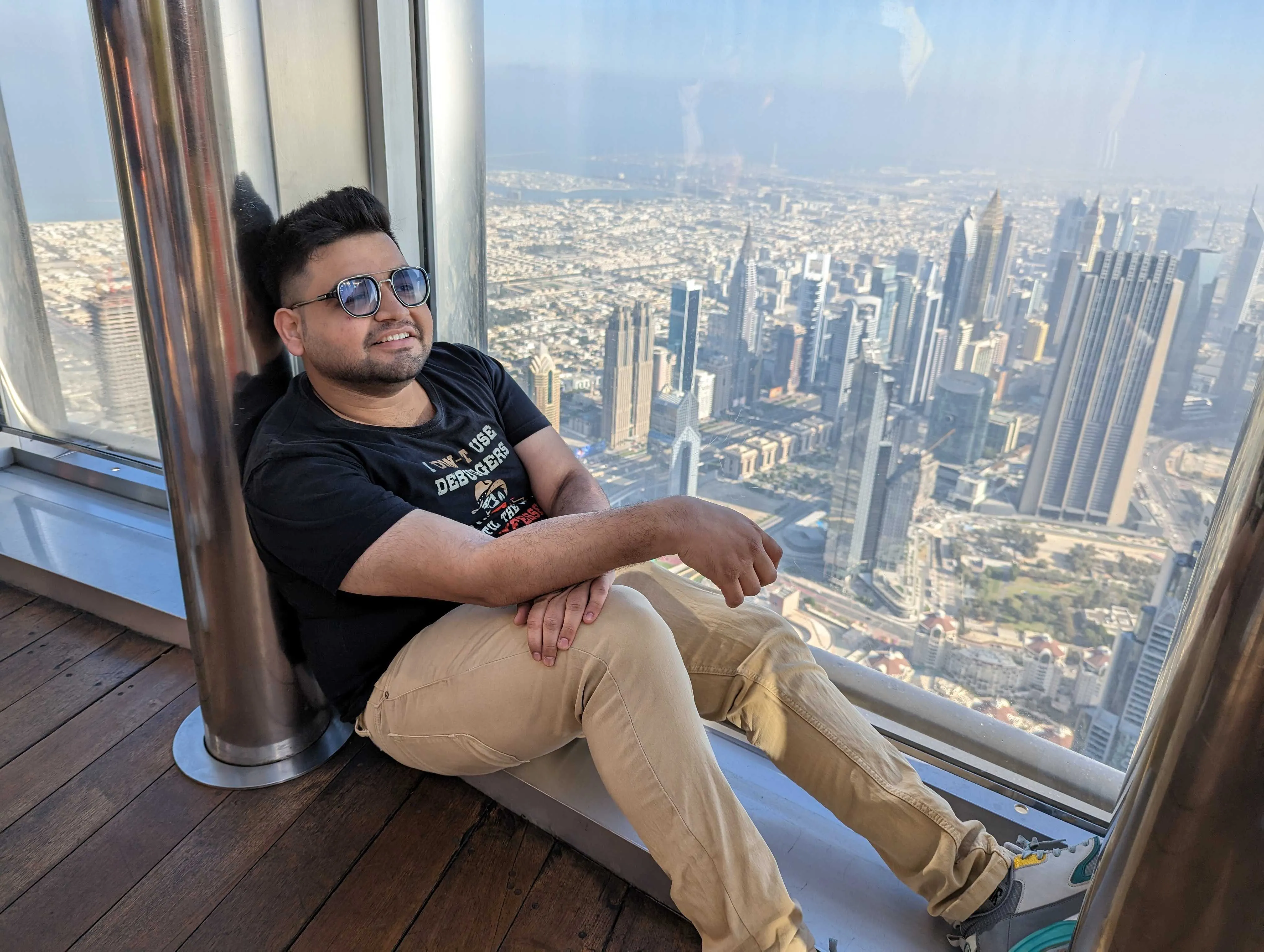 Sitting by the window inside the Burj Khalifa observation deck above the Dubai skyline