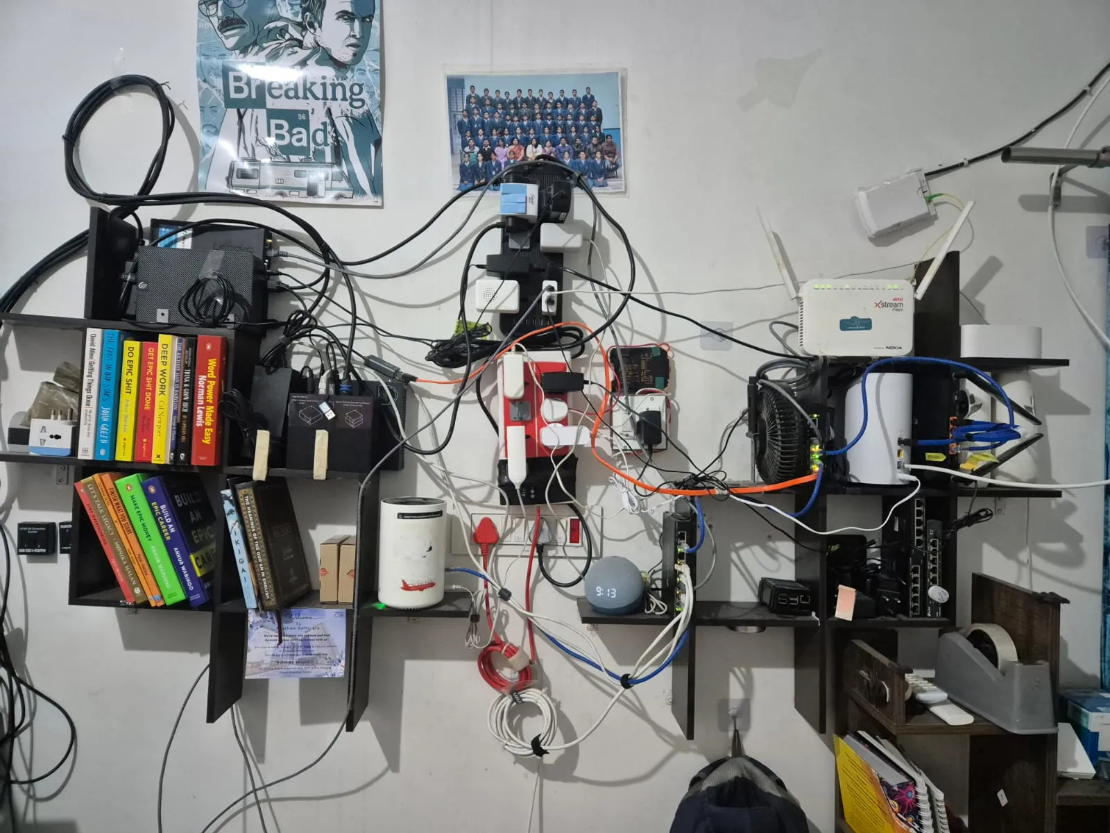 The homelab wall: shelves of boards, routers, drives and a great deal of cable