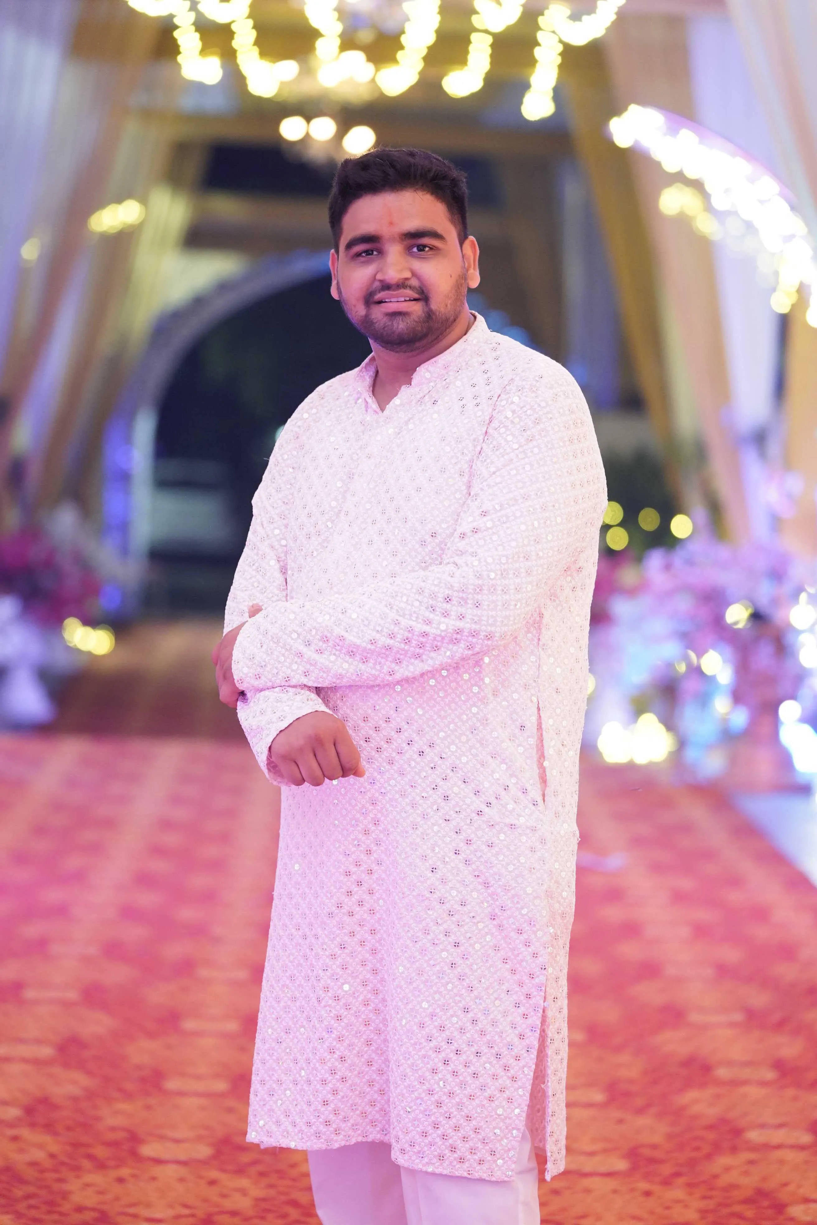 In a white chikankari kurta at a wedding venue
