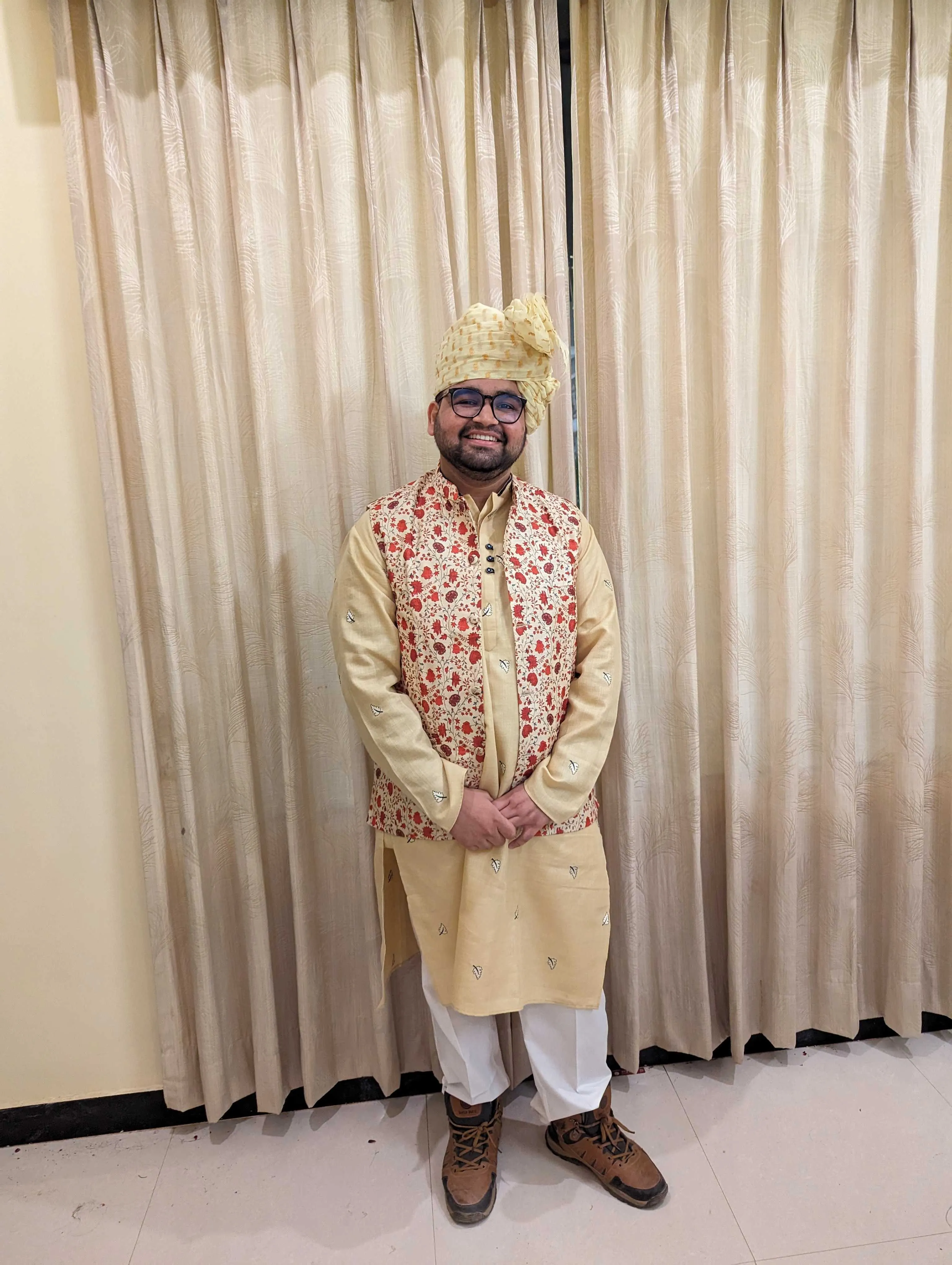 In a cream sherwani and safa for a wedding